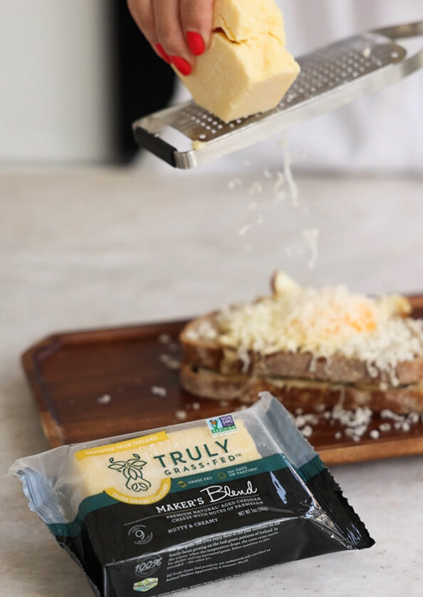 maker;s blend cheese being grated onto bread