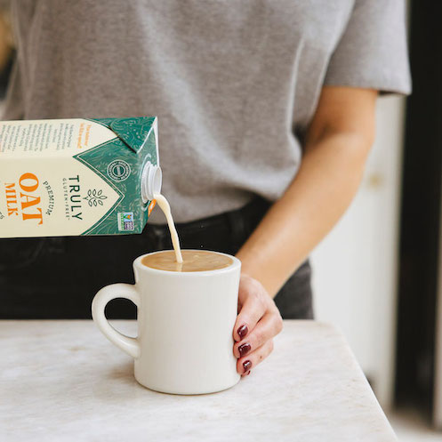 truly oat milk being poured into a cup