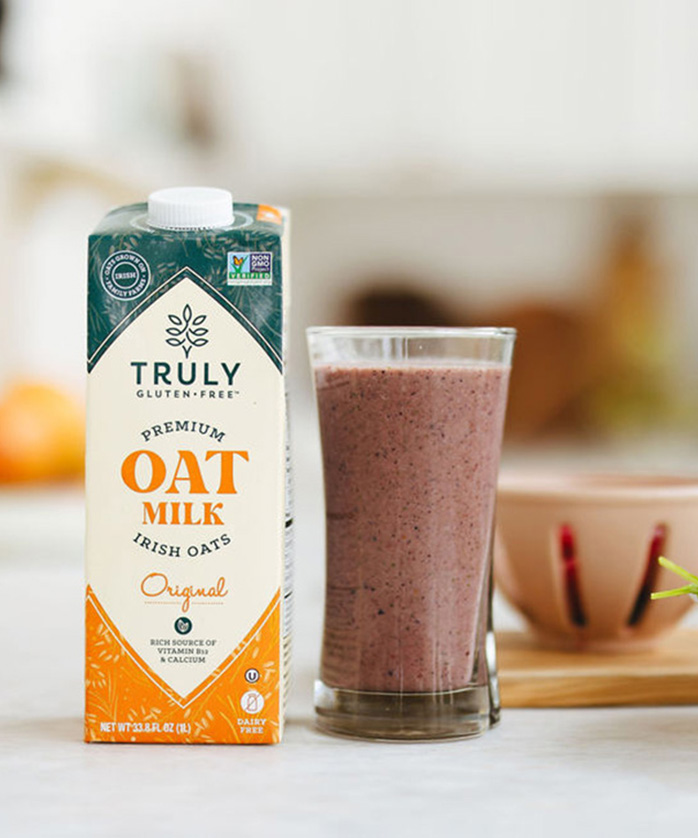 berry smoothie with a carton of original oat milk